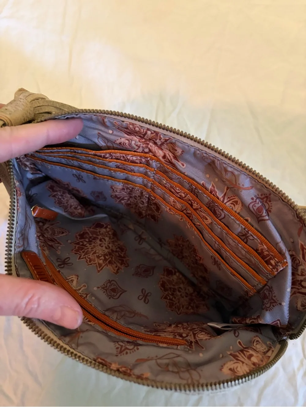 HOBO Sable wristlet in a tan/gold color with tassel